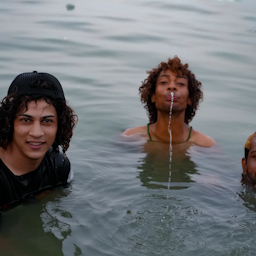سجاد سامي (في الوسط) وأصدقاؤه يتمتعون ببرودة الماء في شط العرب وسط انقطاع التيار الكهربائي وارتفاع درجة الحرارة في العراق. 7 يوليو/ تموز 2021 (تصوير أزهر الربيعي عبر أمواج.ميديا)