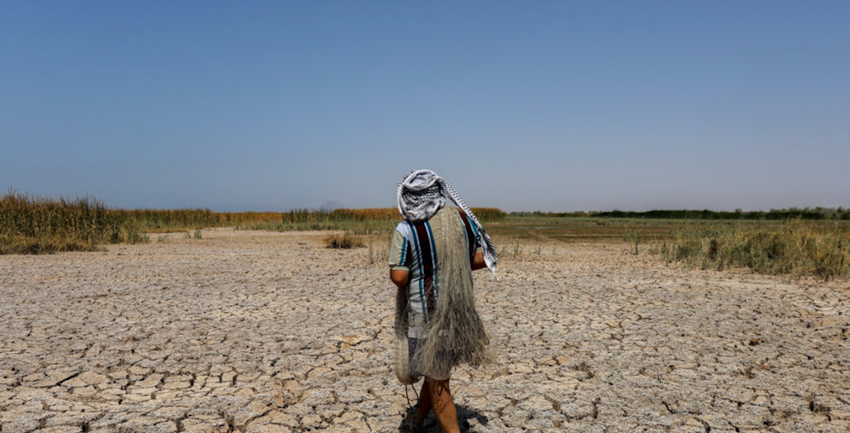An Iranian fisherman passes the dried up Houralazim lagoon in Khuzestan province on July 4, 2021. (Photo by Amir Abidawi via ISNA News Agency) 