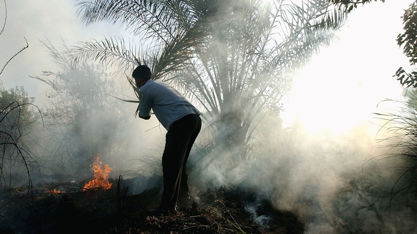 رجل عراقي يواجه حريقًا في بغداد يوم 11 سبتمبر/ أيلول / 2004 (الصورة عبر غيتي إيميجز)