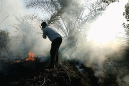 رجل عراقي يواجه حريقًا في بغداد يوم 11 سبتمبر/ أيلول / 2004 (الصورة عبر غيتي إيميجز)