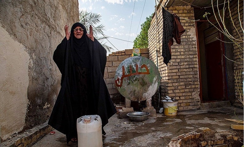إمرأة عربية تكافح من أجل جمع المياه وسط نقص حاد بالقرب من مدينة الأهواز في 4 يوليو/تموز 2021. (الصورة لمهدي بدرامخو عبر وكالة أنباء تسنيم)