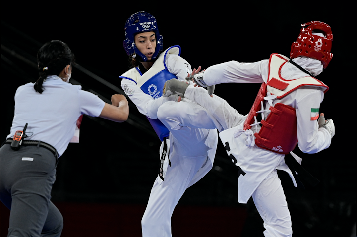 Iranian taekwondoka Nahid Kiani (right) fights Iranian Refugee Team member Kimia Alizadeh (left) in the Tokyo Olympics on July 25, 2021. (Photo via Getty Images)