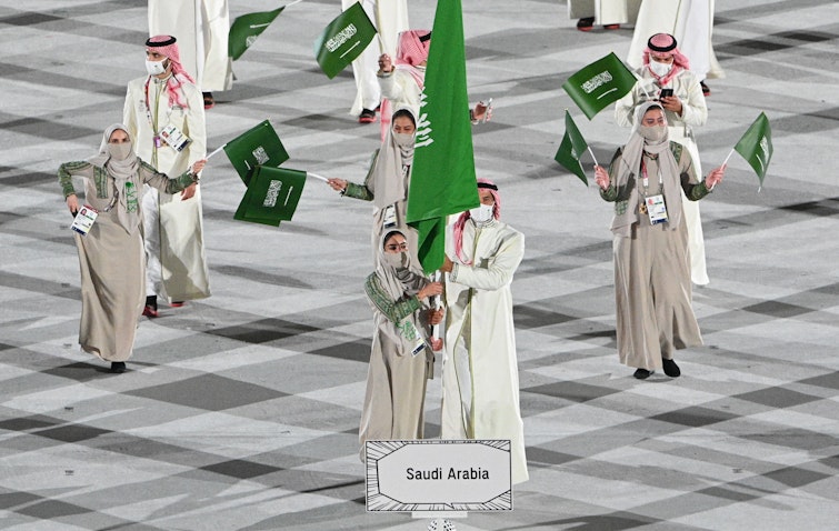لاعبة الجودو السعودية تهاني القحطاني (إلى اليسار) تترأس وفد بلادها في حفل افتتاح أولمبياد طوكيو. 23 يوليو /تموز 2021 (الصورة عبر غيتي إيماجز)
