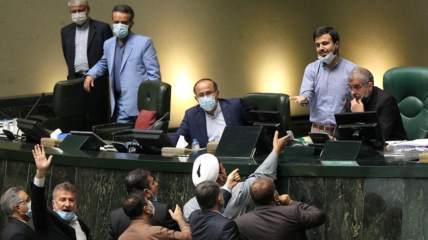Iranian lawmakers surround the podium during a parliamentary session in Tehran on 28 July 2021. (Photo via  ICANA news agency) 
