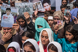 Yazidi women hold pictures of their loved ones killed by the Islamic State group in Sinjar, Iraq on Aug. 3, 2014. (Photo via Getty Images)