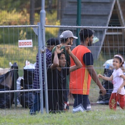 Migrants are seen at a camp near the border town of Kapciamiestis, Lithuania, on July 18, 2021. (Photo via Getty Images)