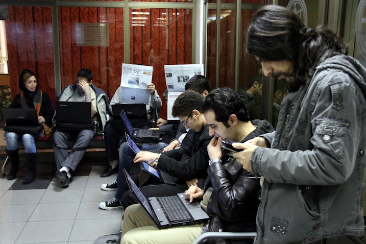سرمایه‌گذاران ایرانی، در حال بررسی قیمت سهام در بورس اوراق بهادار تهران؛ ۲۴ دی ۱۳۹۲. (عکس از گتی ایمیجز)