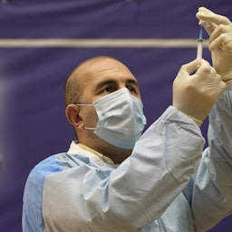 An Iranian health worker fills a syringe with a Covid-19 vaccine at a ceremony to initiate general vaccination in Tehran on Feb. 9, 2021. (Photo via Getty Images)