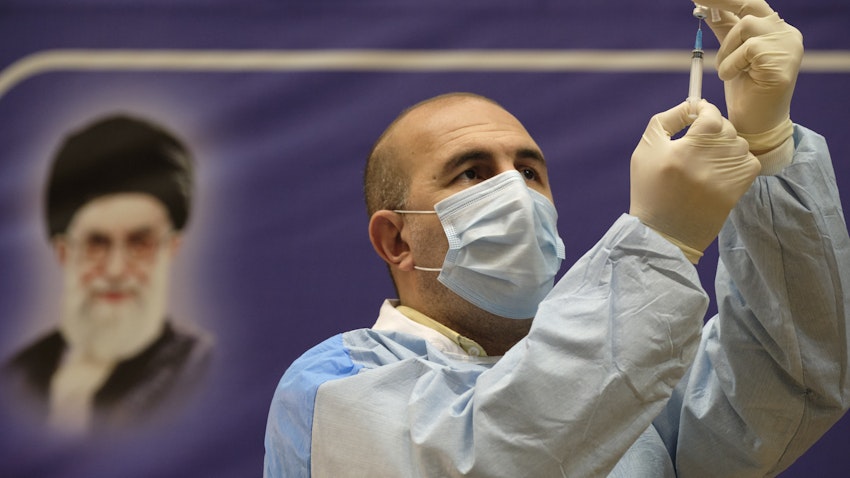 یکی از کارکنان کادر درمان ایران، در حال پر کردن سرنگ با واکسن کووید-۱۹ در مراسم شروع واکسیناسیون عمومی؛ تهران، ۲۱ بهمن ۱۳۹۹. (عکس از گتی ایمیجز)