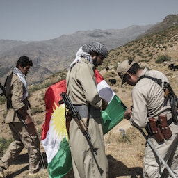 نیروهای حزب دموکرات کردستان ایران در حال برافراشتن پرچم کردستان در پایگاه خود در کوه‌های زاگرس، واقع در مرز ایران و عراق؛ ۵ مرداد ۱۳۹۶/ ۲۷ مرداد ۲۰۱۷. (عکس از گتی ایمیجز )