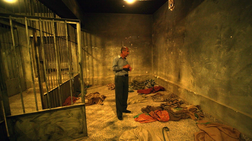 زائر كردي عراقي يقف في زنزانة بمركز تعذيب سابق تم تحويله إلى متحف في مدينة السليمانية شمال العراق. 28 مايو/أيار 2013 (الصورة عبر غيتي إيماجز)