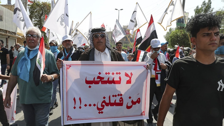 An Iraqi man carries a placard which reads "Don't vote for those who killed us" during a demonstration in Baghdad, Iraq on Oct. 1, 2021. (Photo via Getty Images)