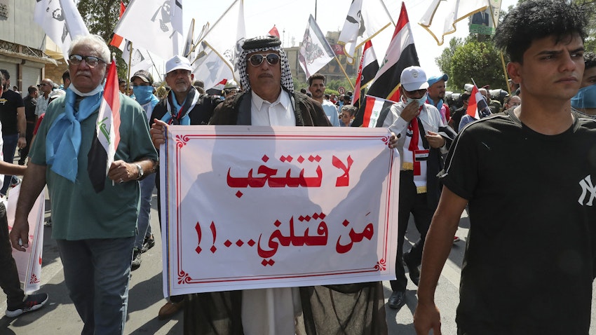 رجل عراقي يحمل لافتة كتب عليها "لا تنتخب من قتلني" خلال مظاهرة في بغداد، العراق. 1 أكتوبر/تشرين الأول 2021. (الصورة عبر غيتي إيماجز)