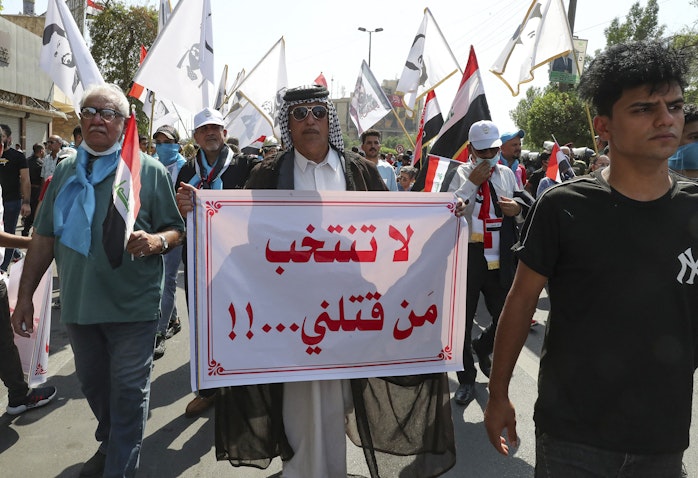رجل عراقي يحمل لافتة كتب عليها "لا تنتخب من قتلني" خلال مظاهرة في بغداد، العراق. 1 أكتوبر/تشرين الأول 2021. (الصورة عبر غيتي إيماجز)