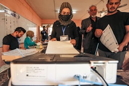 بانوی عراقی، در حال انداختن رأی خود به صندوق‌های انتخاباتی؛ بغداد، عراق، ۱۸ مهر ۱۴۰۰/ ۱۰ اکتبر ۲۰۲۱. (عکس از گتی ایمیجز)