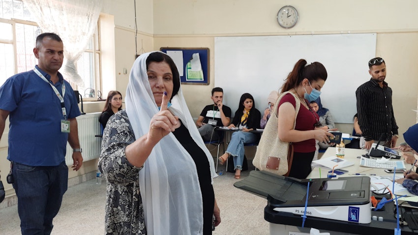 A Kurdish woman casts her ballot at Jamal Tahir polling station in Sulaimaniyah, Iraq on Oct. 10, 2021. (Photo by Dana Taib Menmy) 