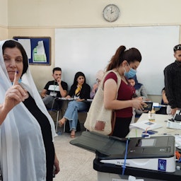زنی کُرد، در حال انداختن رأی خود به صندوق رأی‌گیری در حوزه‌ی انتخاباتی جمال طاهر؛ سلیمانیه، عراق، ۱۸ مهر ۱۴۰۰/ ۱۰ اکتبر ۲۰۲۱. (عکس از دانا طیب منمی)