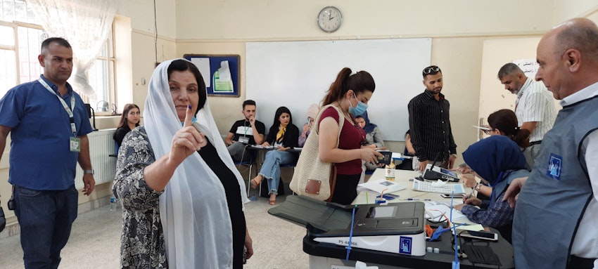 A Kurdish woman casts her ballot at Jamal Tahir polling station in Sulaimaniyah, Iraq on Oct. 10, 2021. (Photo by Dana Taib Menmy) 
