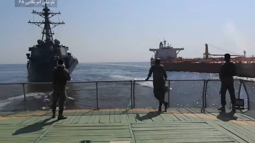 Islamic Revolutionary Guard Corps (IRGC) officers stand on a ship facing a US warship and the oil tanker seized by Iran on Oct. 25, 2021. ( Photo via social media)