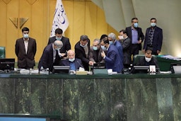 Iranian lawmakers surround the podium during a parliamentary session in Tehran on Nov. 7, 2021. (Photo via ICANA news agency)