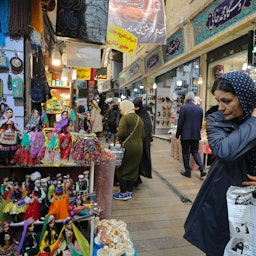 امرأة تنظر إلى دمى ترتدي ملابس محلية معروضة خارج متجر في بازار تاجريش في طهران. 23 أبريل/نيسان 2019 (الصورة عبر غيتي إيماجز)