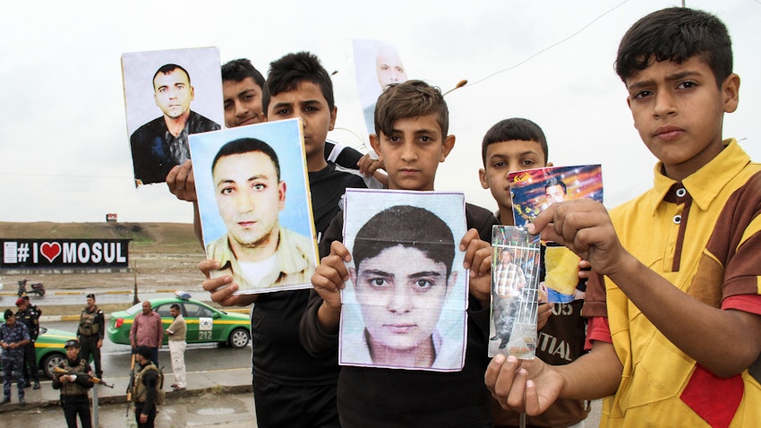 Iraqis hold up portraits of missing relatives who were held captive by the Islamic State group during a demonstration in Mosul, Iraq on Apr. 13, 2018. (Photo via Getty Images)