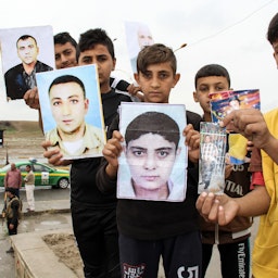 تصاویر افراد مفقود شده در دست اقوام عراقی، گم‌شده‌ها در جریان تظاهراتی در موصل عراق به اسارت گروه داعش درآمدند. موصل، عراق؛ ۲۴ فروردین ۱۳۹۷/ ۱۳ آوریل ۲۰۱۸. (عکس از گتی ایمیجز)