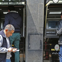 شهروندان ایرانی در حال برداشت پول از دستگاه خودپرداز یکی از شعب بانک ملی ایران در تهران؛ ۴ اردیبهشت ۱۳۹۸. (عکس از گتی ایمیجز)