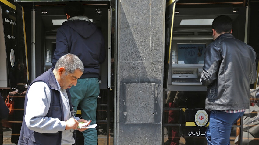 شهروندان ایرانی در حال برداشت پول از دستگاه خودپرداز یکی از شعب بانک ملی ایران در تهران؛ ۴ اردیبهشت ۱۳۹۸. (عکس از گتی ایمیجز)