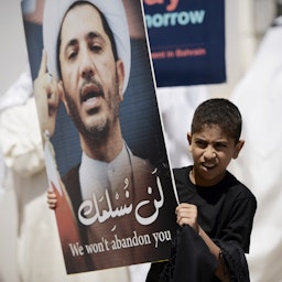 متظاهر بحريني شاب يحمل لافتة عليها صورة الشيخ علي سلمان، زعيم جمعية الوفاق الشيعية المعارضة في الدراز، غرب المنامة، 3 أبريل/نيسان 2015 (الصورة لمحمد الشيخ/وكالة فرانس برس عبر غيتي إيماجز)