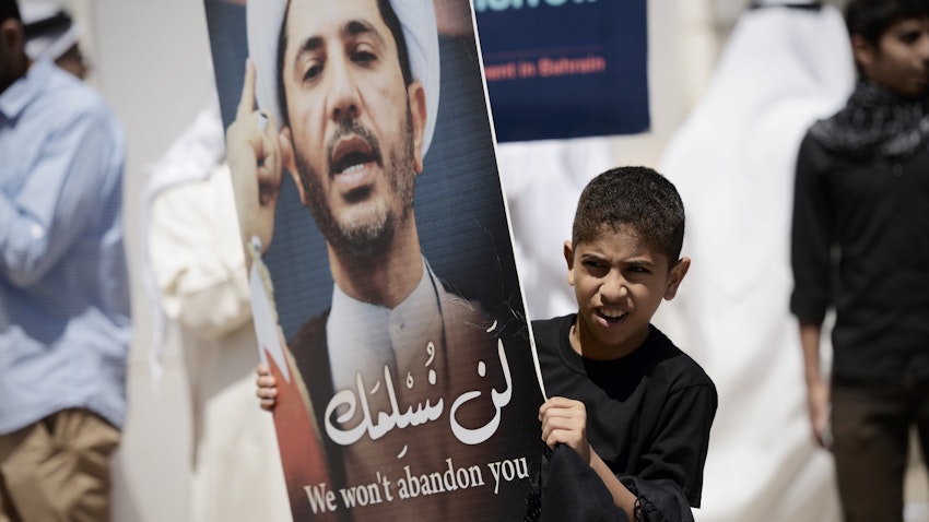 متظاهر بحريني شاب يحمل لافتة عليها صورة الشيخ علي سلمان، زعيم جمعية الوفاق الشيعية المعارضة في الدراز، غرب المنامة، 3 أبريل/نيسان 2015 (الصورة لمحمد الشيخ/وكالة فرانس برس عبر غيتي إيماجز)