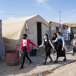 روز اول مدرسه، دختران در راه کلاس در یکی از اردوگاه‌های آوارگان ایزدی؛ نزدیکی شهر دهوک، کردستان عراق، ۱۰ آبان ۱۴۰۰/ ۱ نوامبر ۲۰۲۱. (عکس از گتی ایمیجز)