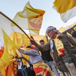 أكراد عراقيون يلوحون بأعلام الحزب الديمقراطي الكردستاني خلال تجمع انتخابي في أربيل، شمال العراق، في 7 أكتوبر/تشرين الأول 2021. (الصورة عبر غيتي إيماجز)