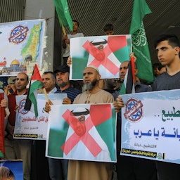 متظاهرون فلسطينيون يرفعون لافتات كتب عليها شعارات مناهضة لاتفاق إبراهيم بين إسرائيل والإمارات، في غزة. 15 أغسطس/آب 2020. (الصورة عبر غيتي إيماجز)
