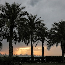مشهد لغروب الشمس وراء أفق مدينة الكويت في 2 مايو/أيار 2021. (الصورة عبر غيتي إيماجز)