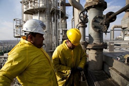 Workers clean a cooling system at the Kar Oil Refinery in Erbil, Iraq on Feb. 29, 2012. (Photo via Getty Images)