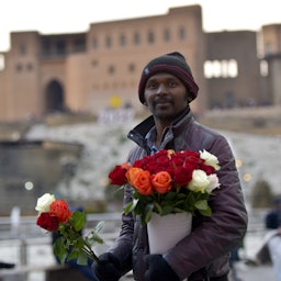 رجل بنغلادشي يبيع الورود في أربيل، العراق. 30 يناير/كانون الثاني 2022. (الصورة عبر غيتي إيماجز)