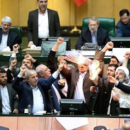 نواب إيرانيون يحرقون نسخة من الاتفاق النووي لعام 2015 في طهران، 9 مايو/أيار 2018 (الصورة عبر ميزان)