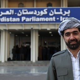 نائب كردي عراقي يقف أمام برلمان إقليم كردستان في أربيل، 14 فبراير/شباط 2019 (الصورة عبر غيتي إيماجز)