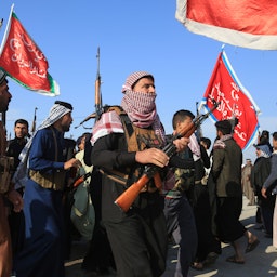 أفراد عشيرة مسلحون ينزلون إلى الشوارع في استعراض للقوة وسط احتجاجات مناهضة للحكومة في كربلاء، العراق. 8 ديسمبر/كانون الأول 2019 (الصورة عبر غيتي إيماجز)