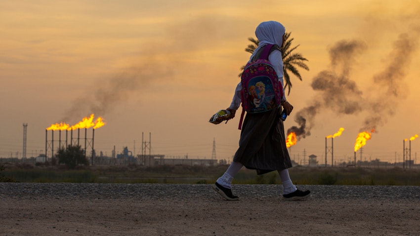 دختری در حال گذر از یک میدان نفتی در جنوب عراق، ۱۴ آذر ۱۴۰۰/ ۵ دسامبر ۲۰۲۱. (عکس از گتی ایمیجز)
