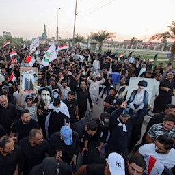 Supporters of Iraqi cleric Muqtada Al-Sadr march while carrying posters of him in Najaf, Iraq on Aug. 27, 2021. (Photo via Getty Images)