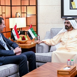 Syrian President Bashar Al-Assad (L) sits with Dubai's ruler Mohammed bin Rashid Al Maktoum on Mar. 18, 2022. (Handout photo via WAM)