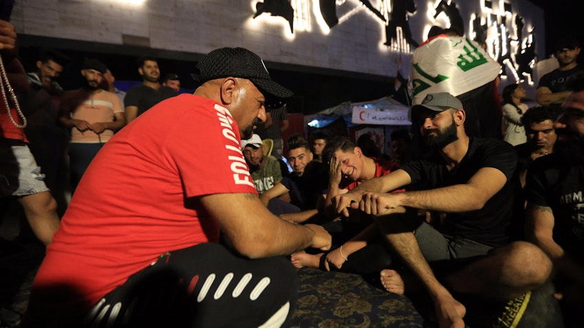 المشاركون يلعبون لعبة المحيبس العراقية التقليدية خلال شهر رمضان في ساحة التحرير ببغداد، العراق. 1 مايو/أيار 2020 (الصورة عبر غيتي إيماجز)