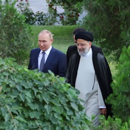 Russian President Vladimir Putin walking alongside Iranian President Ebrahim Raisi in Tehran, Iran on July 19, 2022. (Photo via Iranian presidency)
