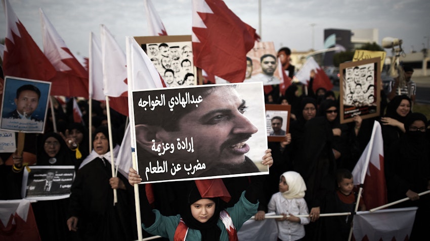 A Bahraini girl holds a portrait of jailed human rights activist Abdulhadi al-Khawaja during an anti-government protest near Manama, Bahrain on Sept. 5, 2014. (Photo via Getty Images)