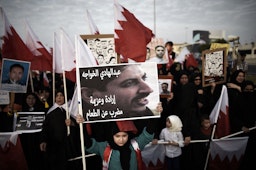 تصویری از عبدالهادی الخواجه، فعال حقوق بشر زندانی، در دست یک دختر بحرینی در جریان تظاهرات ضد دولتی در نزدیکی منامه؛ بحرین، ۱۴ شهریور ۱۳۹۳/ ۵ سپتامبر ۲۰۱۴. (عکس از گتی ایمیجز)