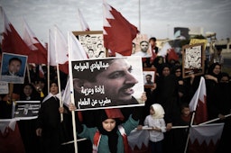 A Bahraini girl holds a portrait of jailed human rights activist Abdulhadi al-Khawaja during an anti-government protest near Manama, Bahrain on Sept. 5, 2014. (Photo via Getty Images)