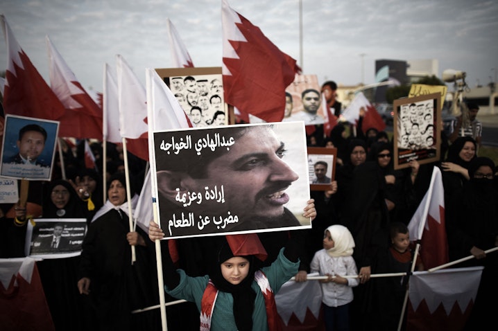 A Bahraini girl holds a portrait of jailed human rights activist Abdulhadi al-Khawaja during an anti-government protest near Manama, Bahrain on Sept. 5, 2014. (Photo via Getty Images)