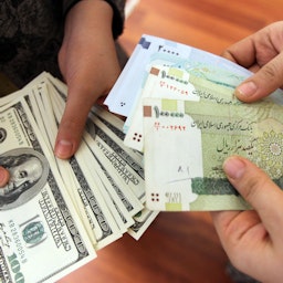 Iranians exchanging the United States 100-dollar bills and Iran's Rial banknotes in Tehran on Jan. 12, 2012. (Photo via Getty Images)